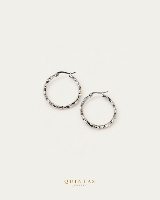 Rumi Textured Silver Hoop Earrings — source-backed complete hoop pair, source-backed main view, small balanced off-white composition and authentic canonical logo
