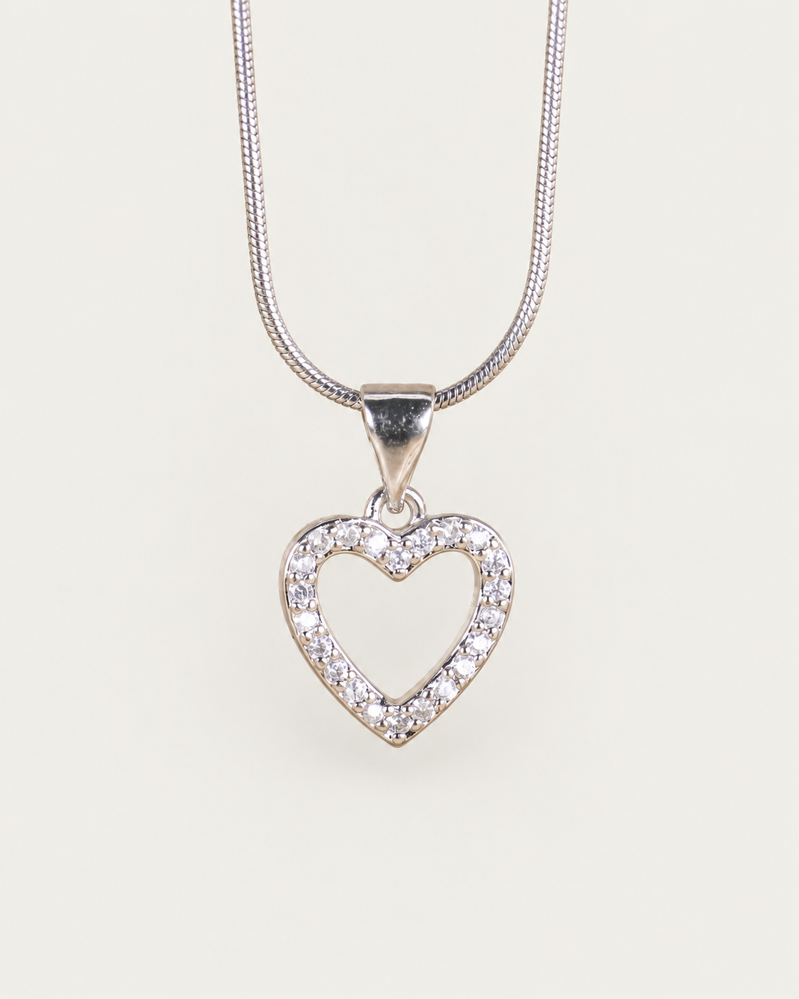 Arielle Silver Heart Necklace — snake chain, front hero, neutral greige background