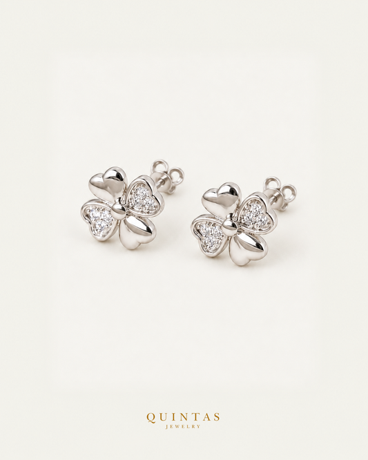 Clover silver stud earrings pair with visible straight stems and butterfly stoppers