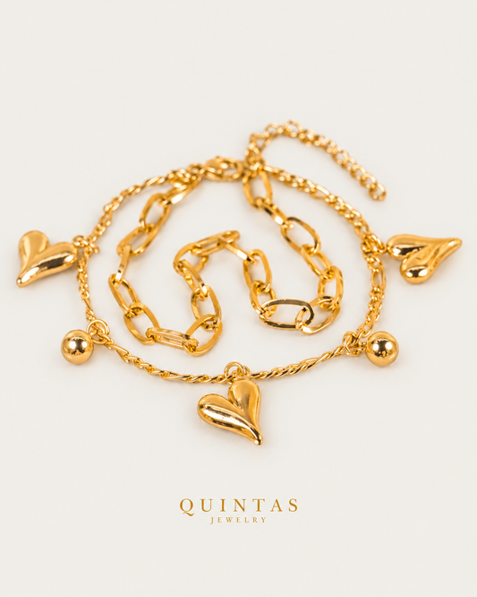 Juliette Heart Charm Bracelet — gold bracelet, front hero, neutral greige background