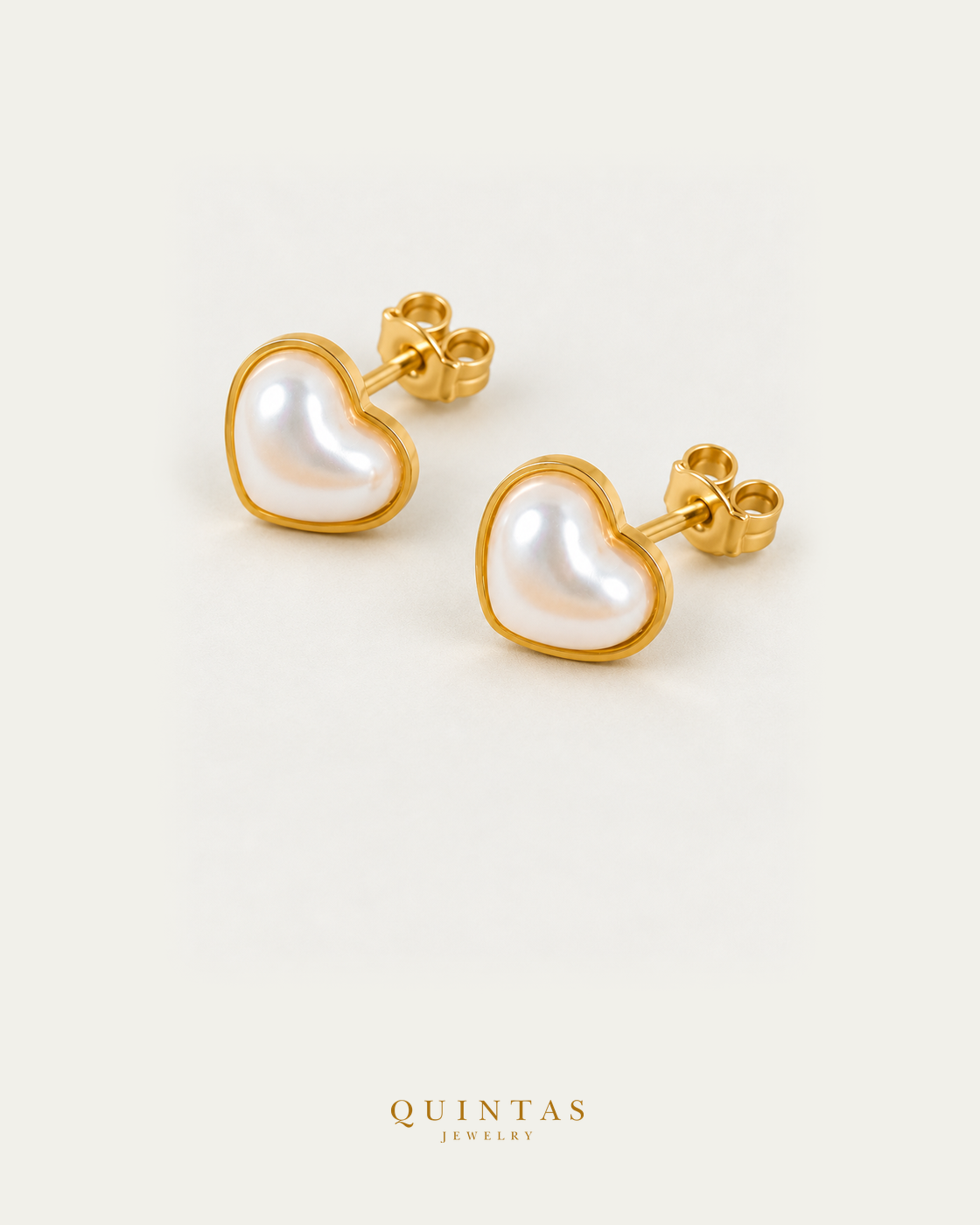 Pearl stud earrings pair, alternate angle with visible pushback stems on off-white