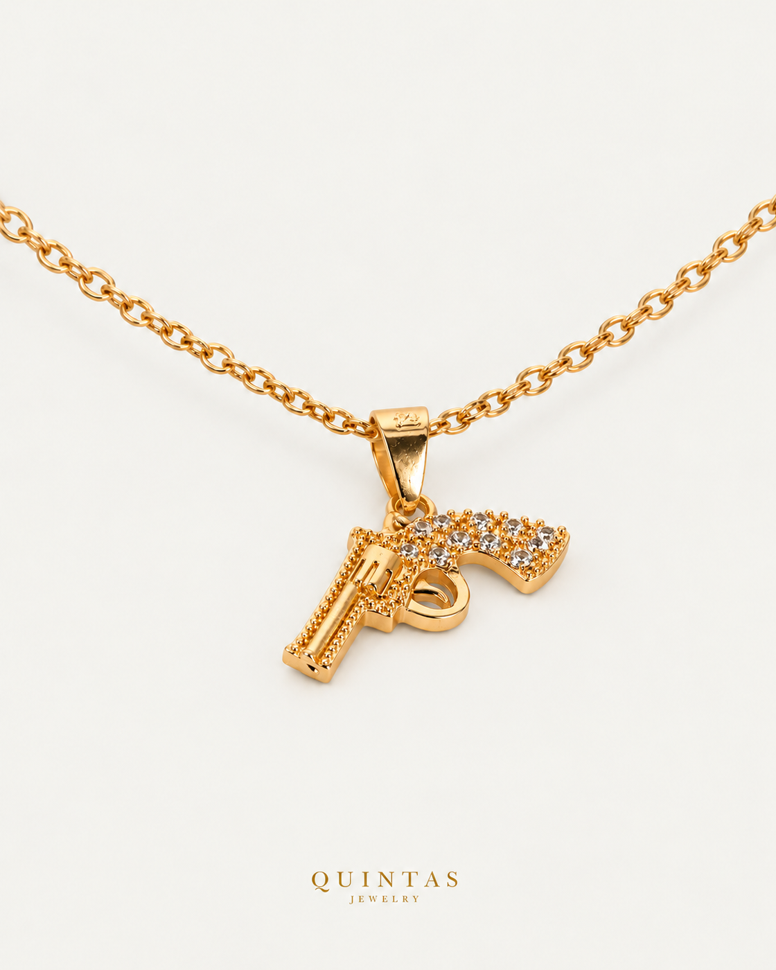 Pistol Charm Necklace — source-verified cable oblique view, off-white background, canonical gold logo