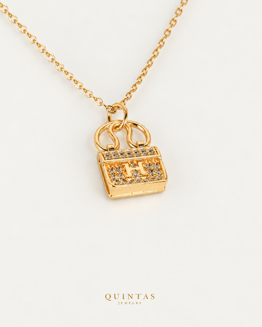 Mini Bag Necklace — gold cable chain, companion view, canonical Quintas logo