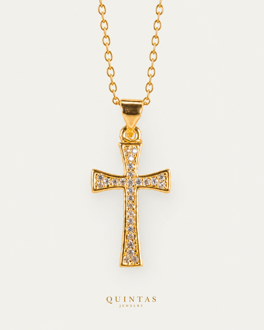 Zariel Cross Necklace — gold cable, frontal hero, neutral greige; canonical Quintas Jewelry logo