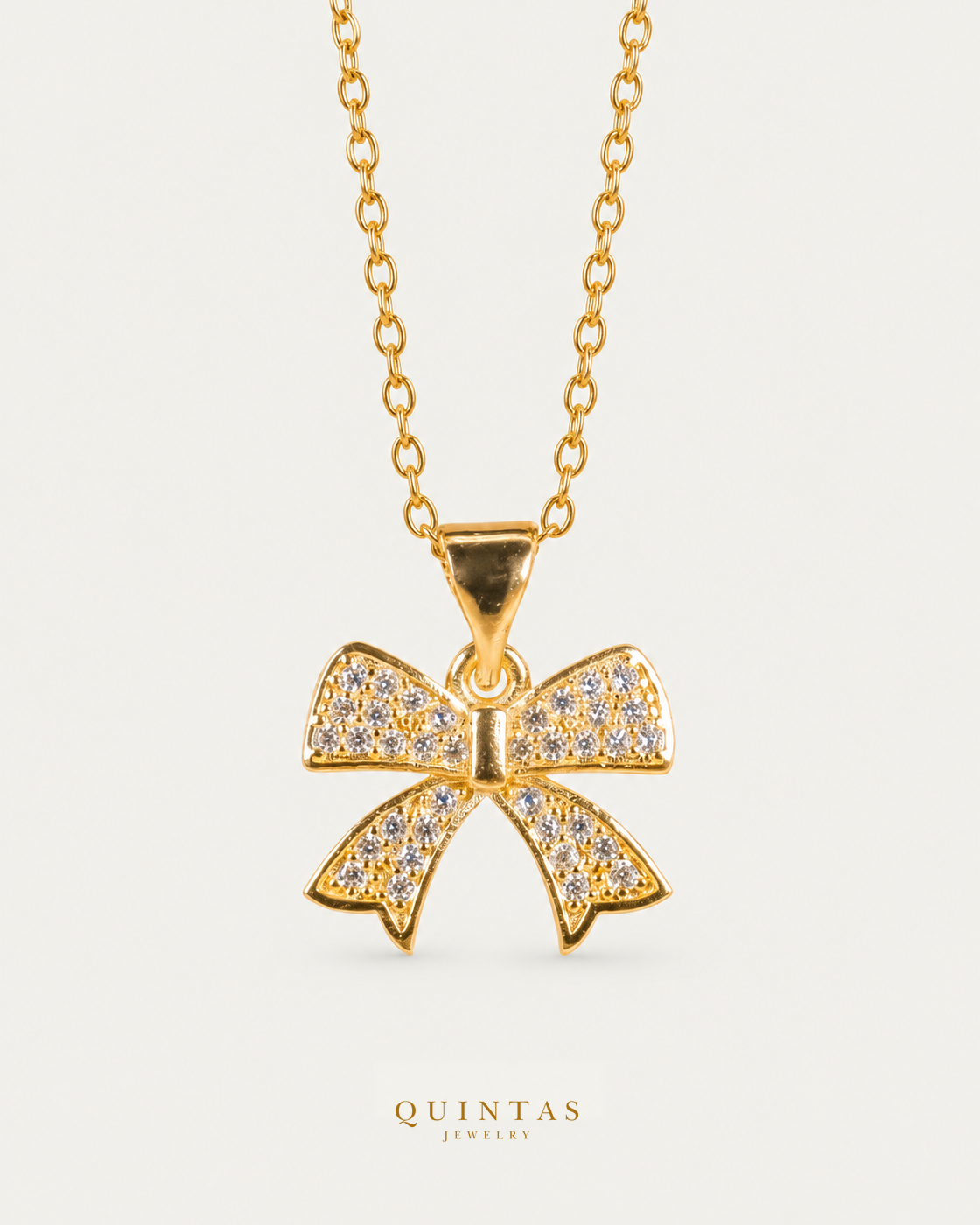 Velora Bow Necklace cable chain hero angle on neutral greige