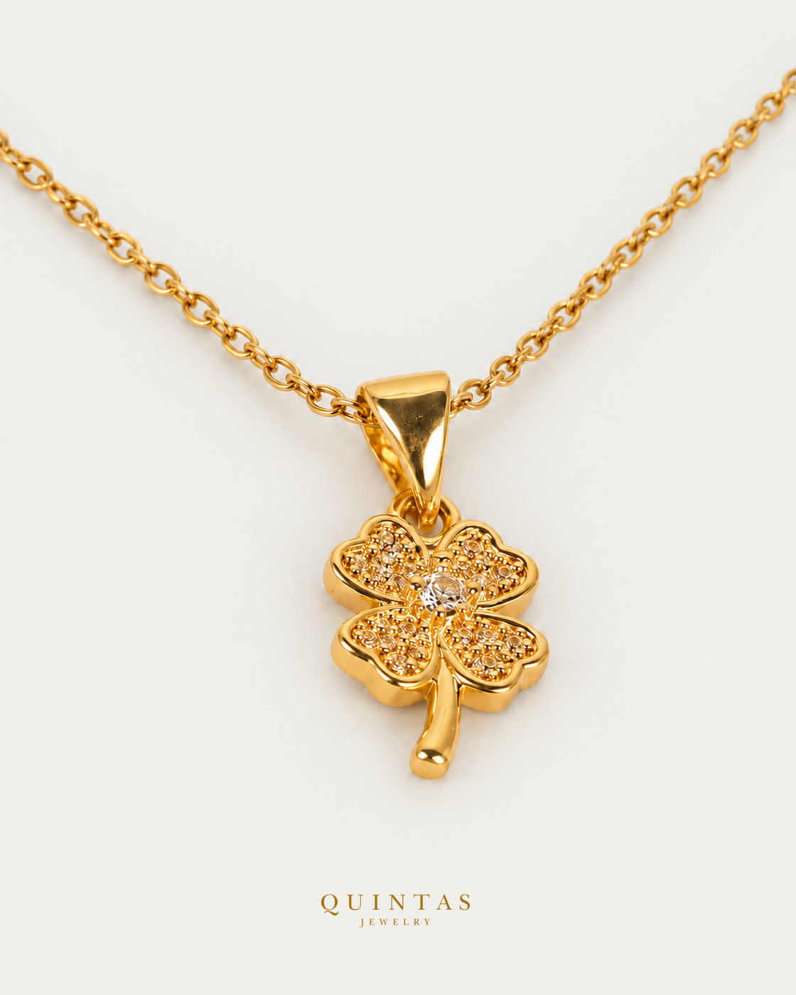 Lucky Clover Necklace — source-verified cable oblique view, off-white background, canonical gold logo