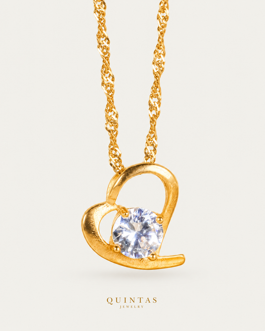 Eternal Solitaire Heart Necklace — source-verified Singapore front view, off-white background, canonical gold logo