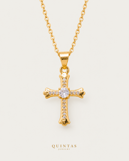 Faith Cross Diamond Necklace cable chain hero photographed angle on neutral greige; canonical Quintas Jewelry logo