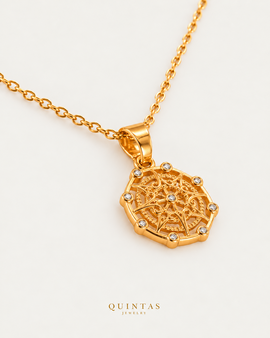 Amelia's Compass Necklace cable chain companion photographed angle on neutral greige; canonical Quintas Jewelry logo