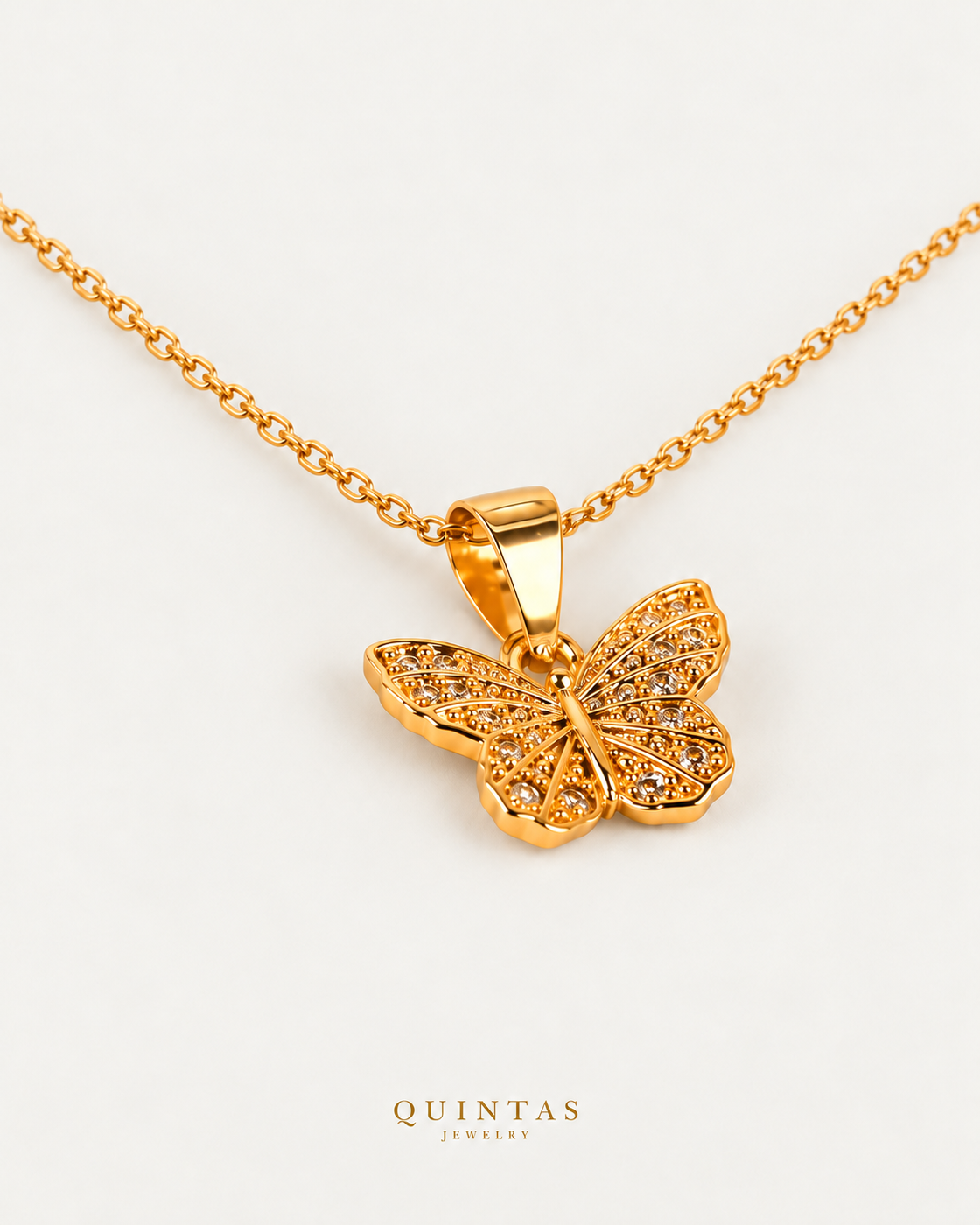 Caroline Butterfly Necklace — source-verified cable oblique view, off-white background, canonical gold logo