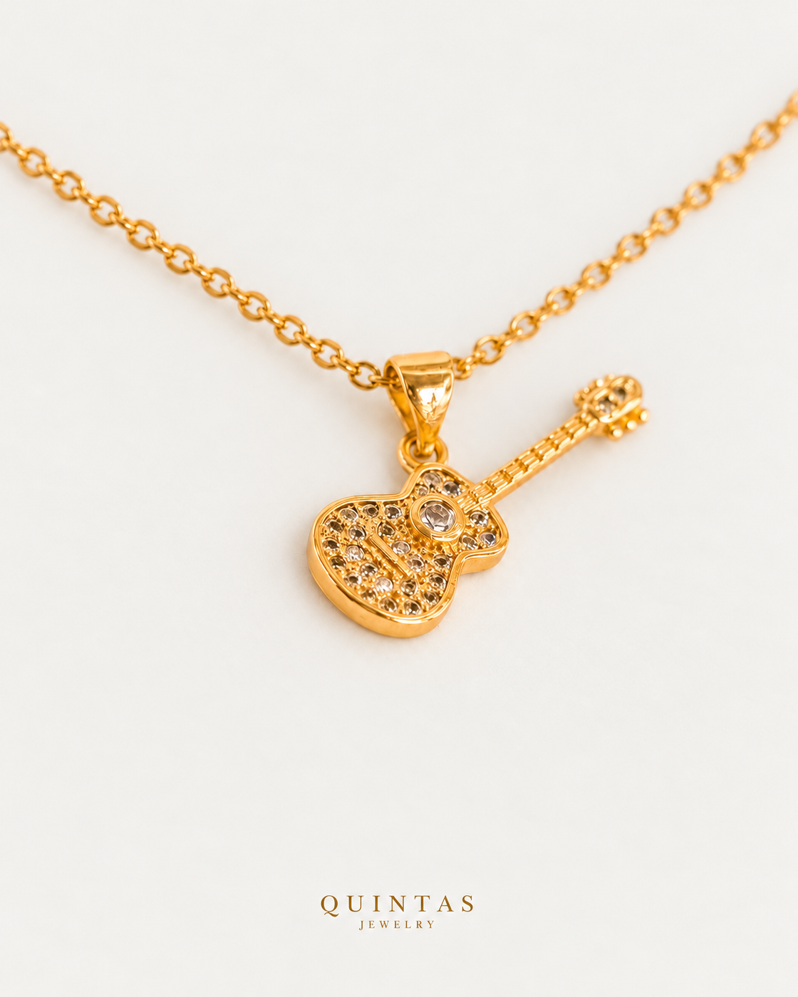 The Guitar Necklace gold cable chain, companion view, canonical Quintas logo