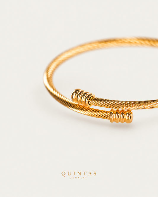 Maserati Celtic Bangle gold bracelet companion photographed angle on neutral greige