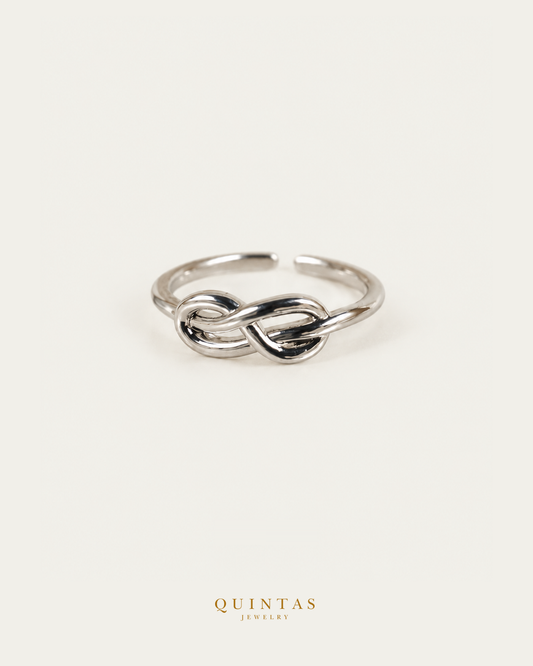 Infinity Silver Ring (Adjustable) standalone lying view with smaller framing on neutral greige
