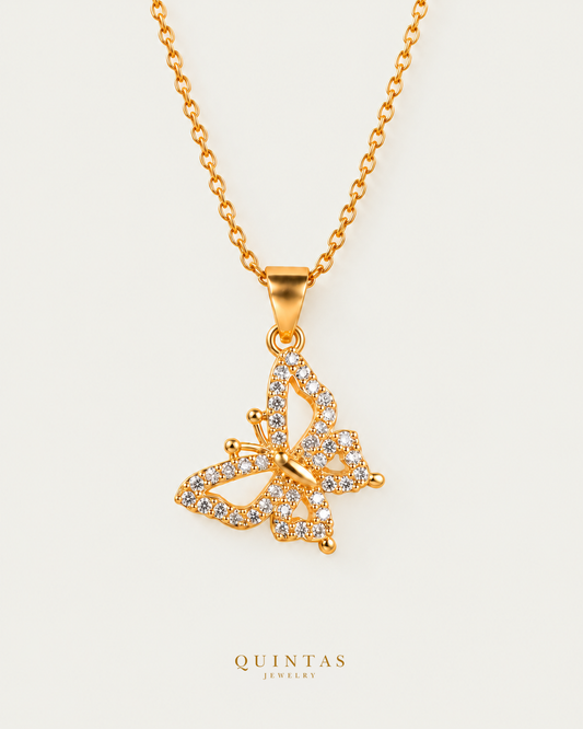 Iris Butterfly Necklace — gold cable chain, neutral greige; canonical Quintas Jewelry logo