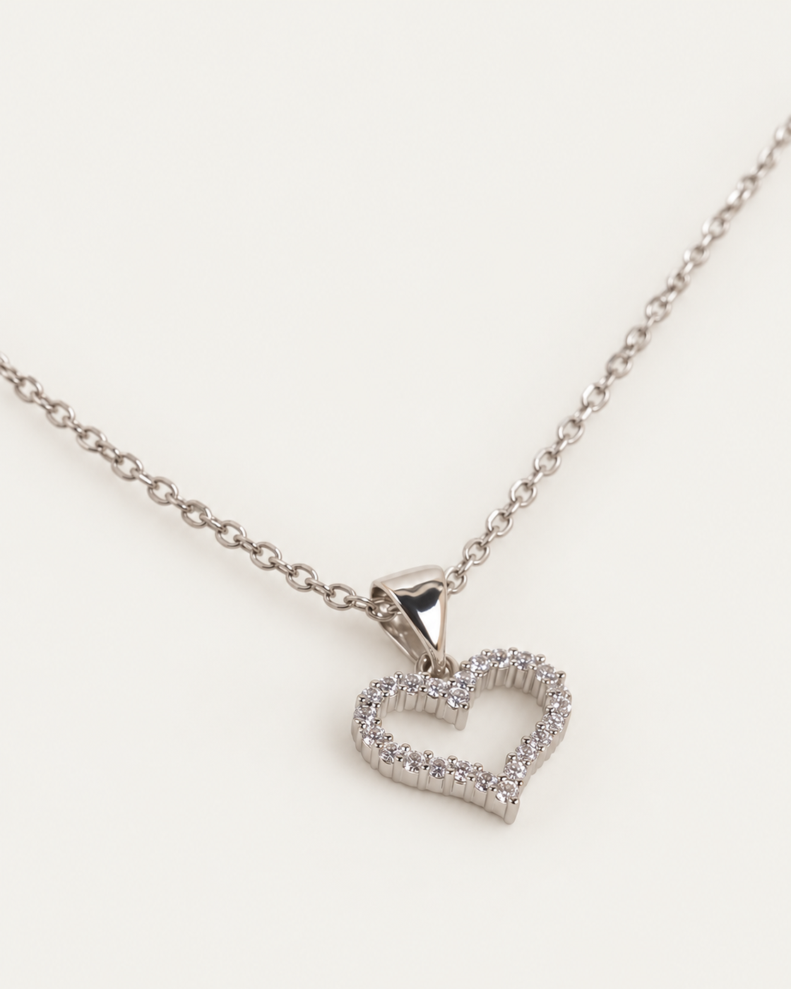 Althea Iced Heart Silver Necklace cable companion photographed angle on neutral greige