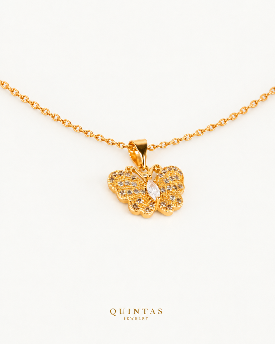 Jane Butterfly Diamond Necklace — gold cable, genuine oblique angle, neutral greige; canonical Quintas Jewelry logo