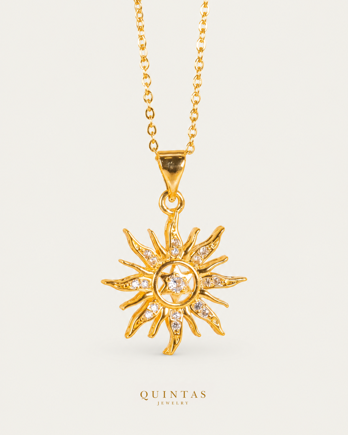 Solara Sun Necklace — gold cable, frontal hero, neutral greige; canonical Quintas Jewelry logo