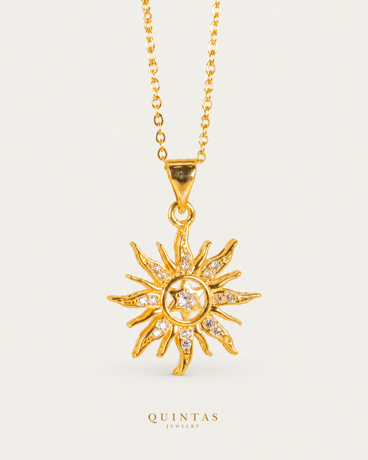 Solara Sun Necklace — gold cable, frontal hero, neutral greige; canonical Quintas Jewelry logo
