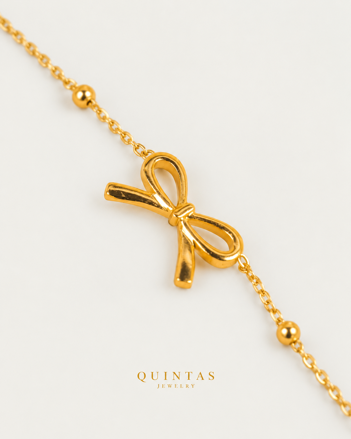 Bow Charm Bracelet, alternate physical-source detail angle, neutral greige