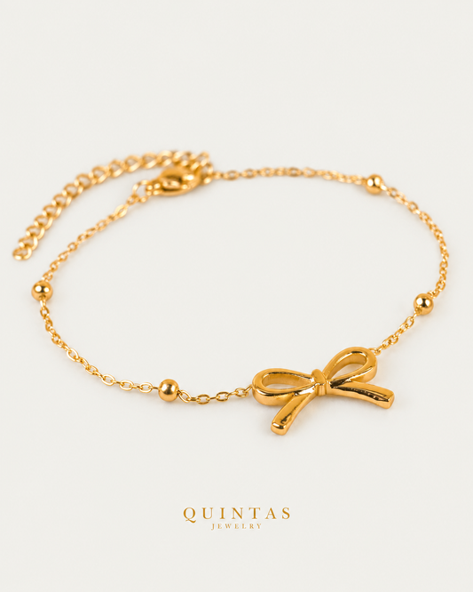 Bow Charm Bracelet, full physical-source view, neutral greige
