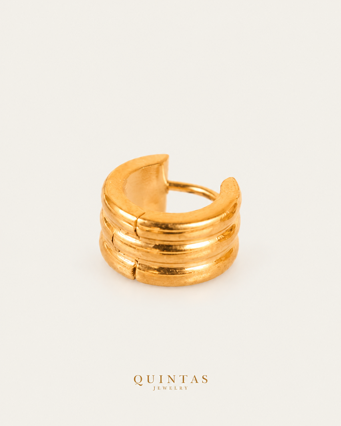Emily gold triple hoop earring lying view on neutral greige, based on actual product photo