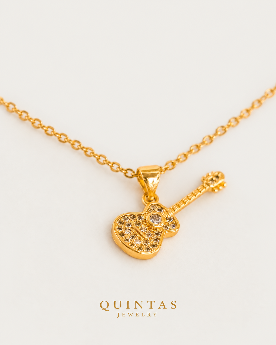 The Guitar Necklace gold cable chain companion on neutral greige