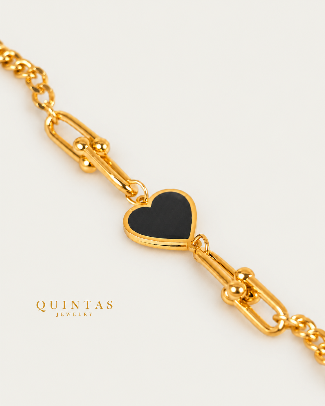 Vina Black Heart Bracelet — gold bracelet, genuine oblique detail, neutral greige background